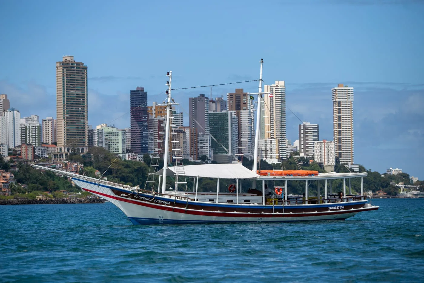 Escuna navegando com o skyline de Salvador ao fundo